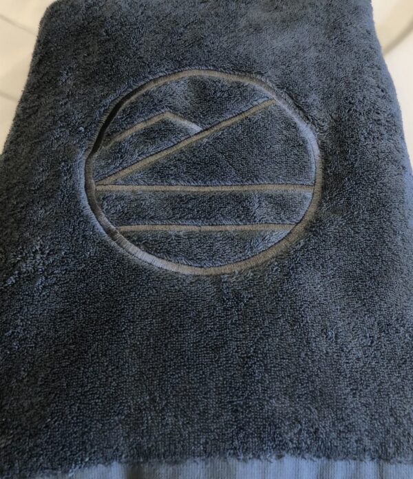 Luksuriøst badehåndkle i bomull med høy absorberingsevne og brodert logo. Perfekt til spa, badstue og hverdagsbruk – komfort og kvalitet i ett.